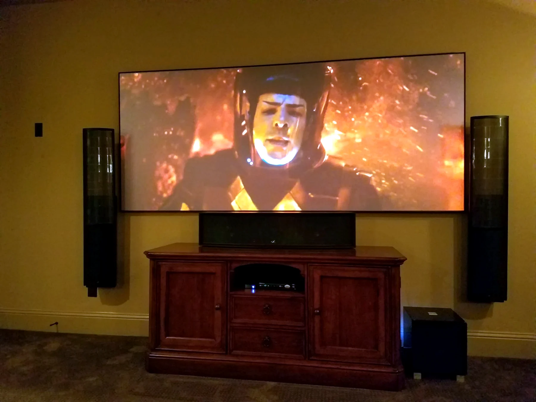 Home theater projection screen with tower speakers center channel cabinet and subwoofer