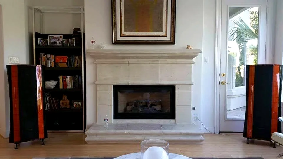 Two-channel listening room with floorstanding speakers beside fireplace