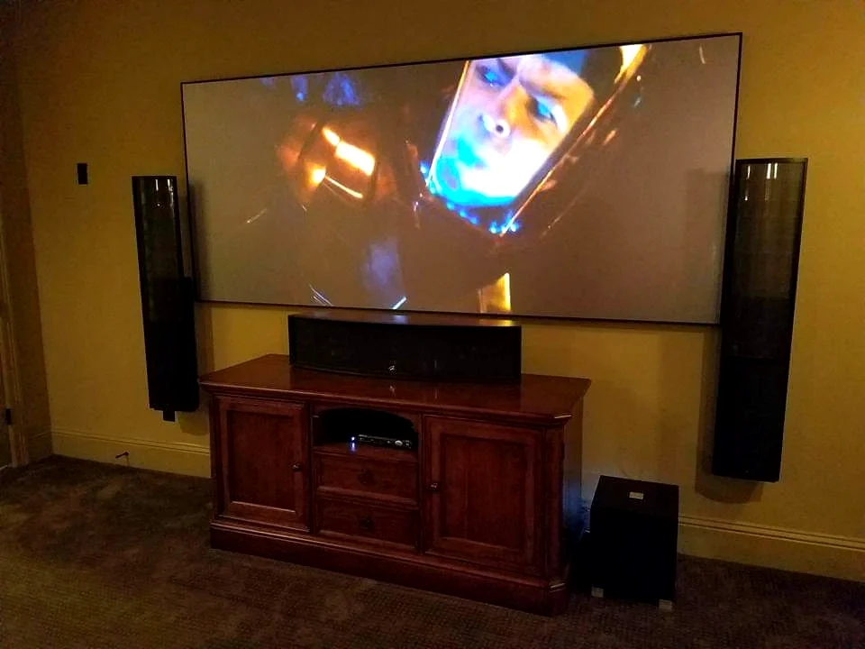 Luxury Houston home theater with large screen, tower speakers, and clean AV design